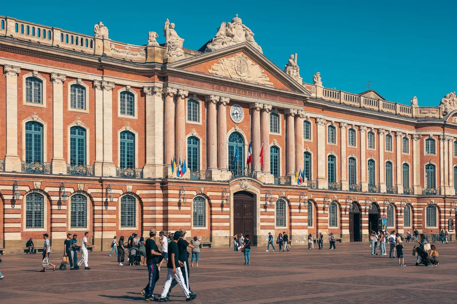 La place du Capitole à Toulouse, façade de brique rose sous un ciel bleu
